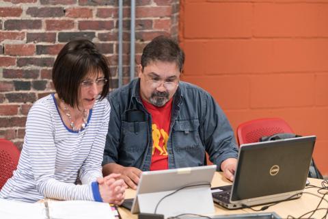 two people viewing a computer screen